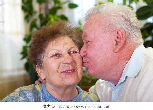 可爱的老夫妇在家里接吻的照片晚年幸福微笑的老人